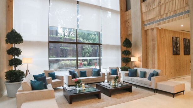 A spacious living area with large windows, multiple seating arrangements, and a wooden accent wall.