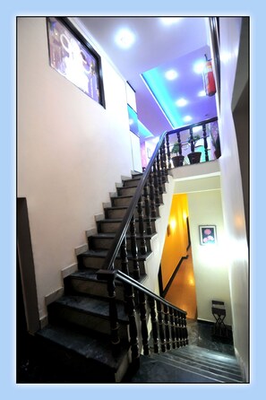 A staircase with black railings and steps, leading to an upper floor. - Aachman Regency (Shimla)
