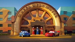 Ein großes Tor mit der Aufschrift "WELL MOTEL" darüber, begleitet von zwei animierten Autos.
