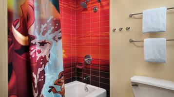 A bathroom with a red tiled shower wall, a white bathtub, and a towel rack with two towels.