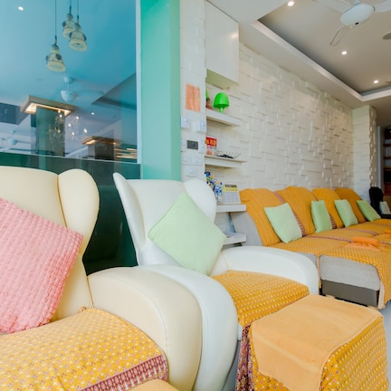 A hotel reception area with a seating area featuring multiple chairs and a reception desk.
