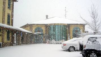 Een gebouw met een sneeuwbedekte dak en een geparkeerde auto ervoor.