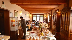 A buffet setup with various food items and a person serving. - Hotel Corte Vecchia (San Prospero)