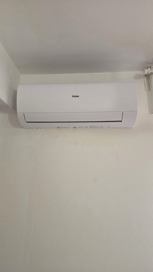 A white Haier air conditioner mounted on a plain wall.