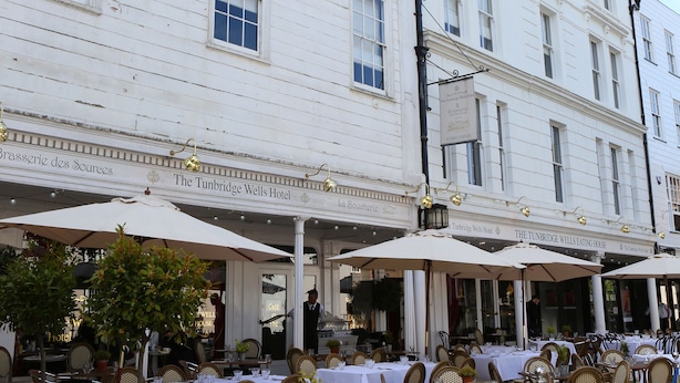 Um edifício branco com várias janelas e uma placa com a inscrição 'The Tunbridge Wells Hotel'.