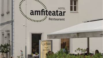 A building with a sign that reads "amfiteatar HOTEL & RESTAURANT".