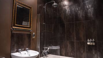 Een moderne badkamer met een bad, een douche met glazen wanden en een wastafel.