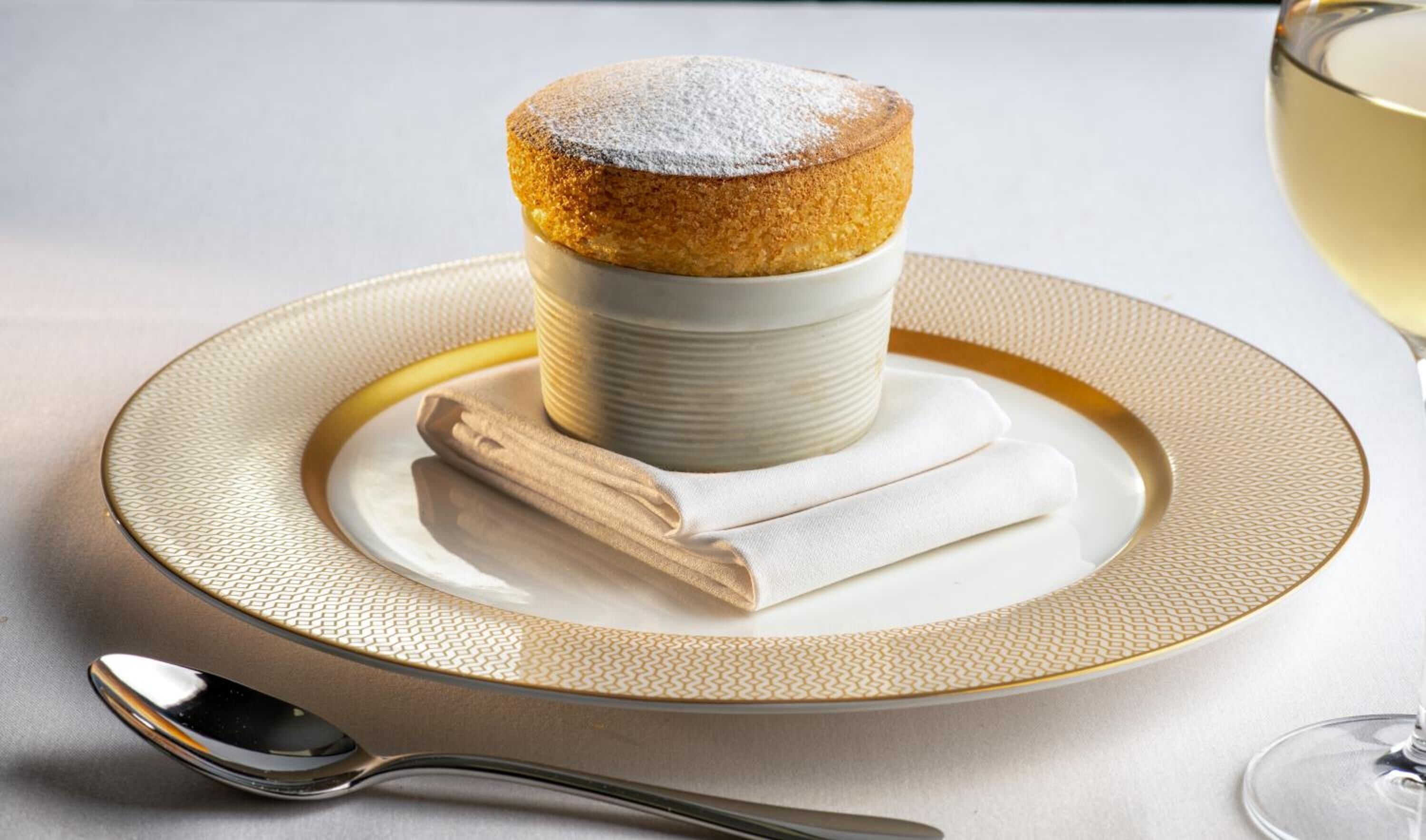 A dessert on a plate with a napkin and a spoon.