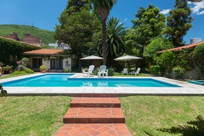Una piscina al aire libre, sombrillas