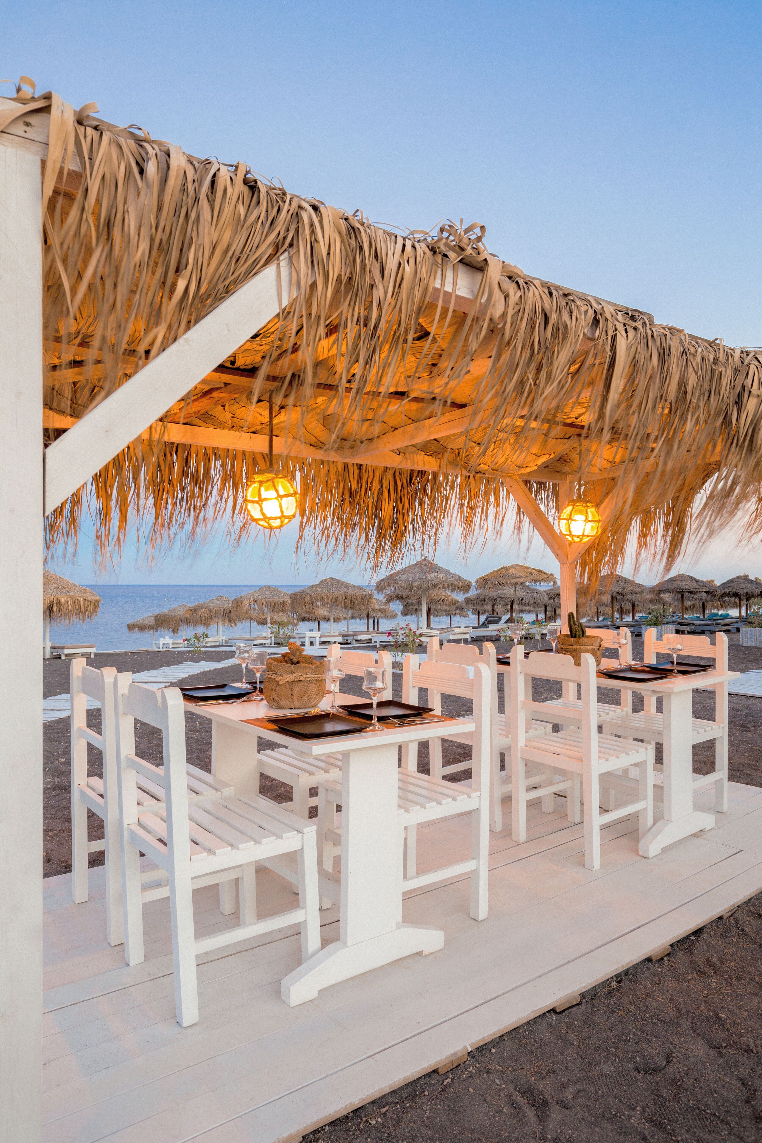 Praia particular, areia preta, espreguiçadeiras, guarda-sóis 