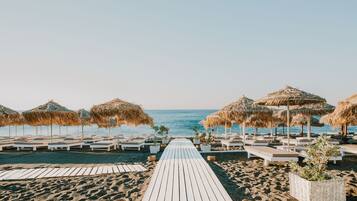 Plage privée, sable noir, chaises longues, parasols