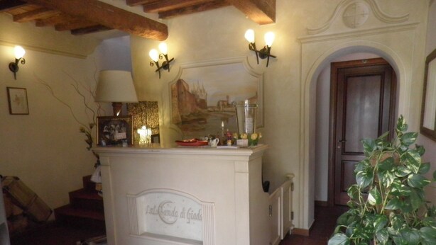 Una habitación con una zona de bar blanca, una escalera y una puerta que da a otra estancia.
