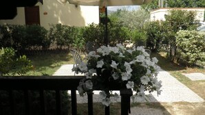 Un patio con un arreglo floral colgante, una mesa y un área de estar techada.