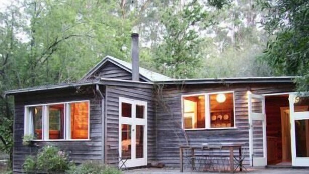 A rustic cabin with a chimney, large windows, and a porch. - Allenvale (Lorne)