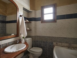 Bañera profunda, cabezal de ducha tipo lluvia, secador de pelo, toallas