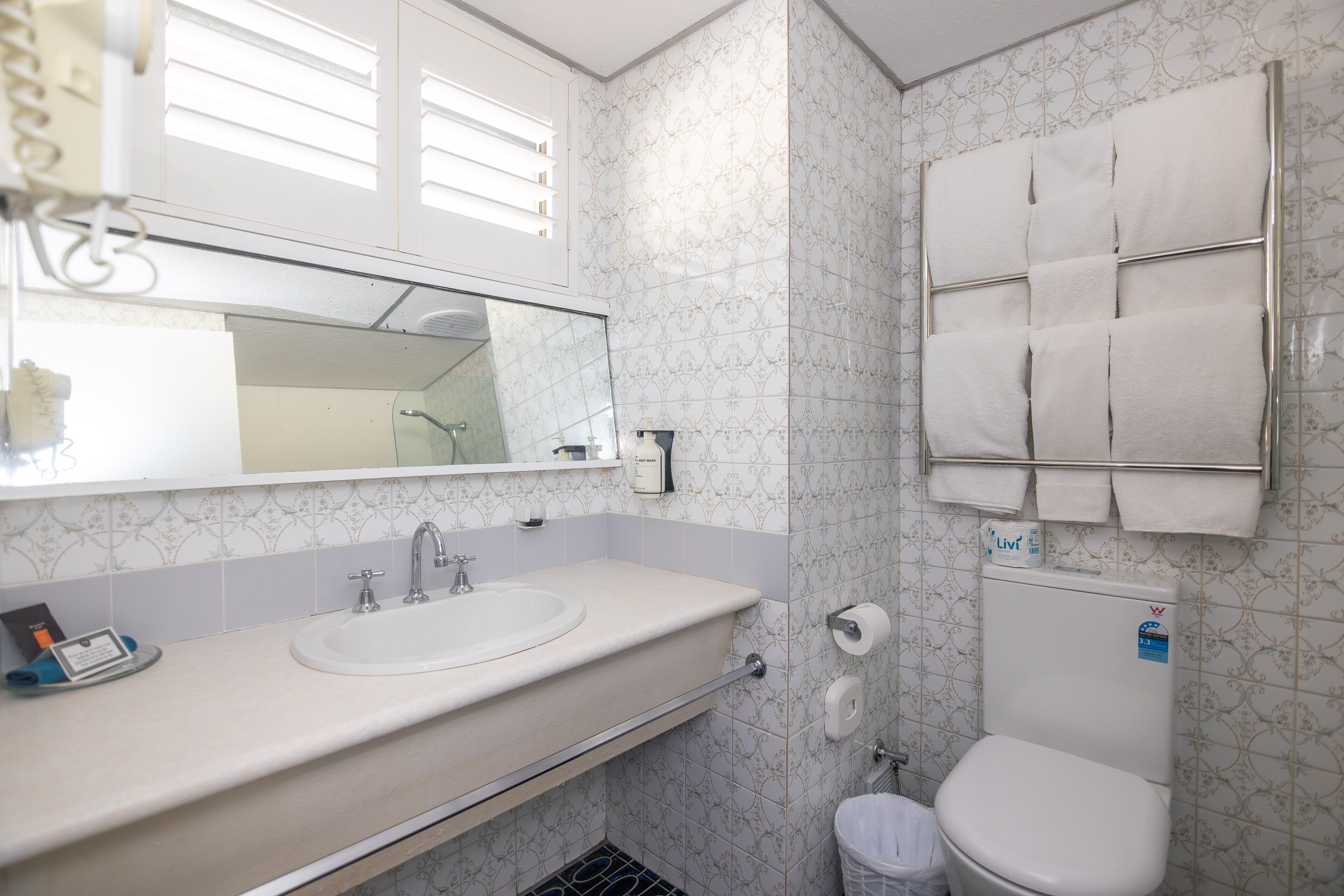 Un baño con lavamanos, espejo e inodoro.