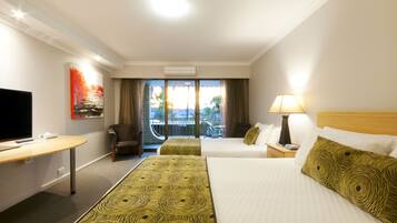 A hotel room with a TV, a desk, two beds, a chair, a balcony with a view, and a painting on the wall.
