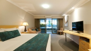 A hotel room with a bed, a desk, a television, and a balcony with a view. - Dog Rock Motel (Mount Clarence)