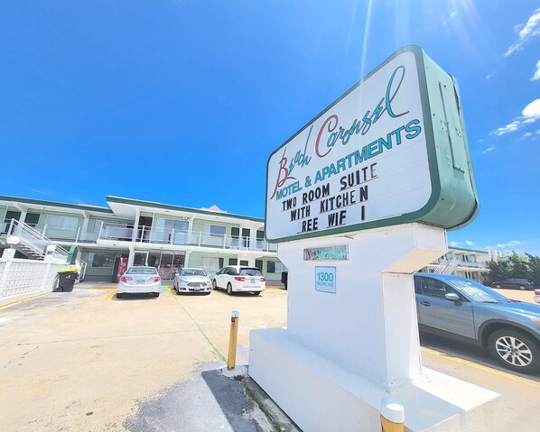 Une enseigne indiquant « Bach Hotel & Apartments » et faisant la publicité d’une suite de deux pièces avec cuisine et accès Wi-Fi gratuit.