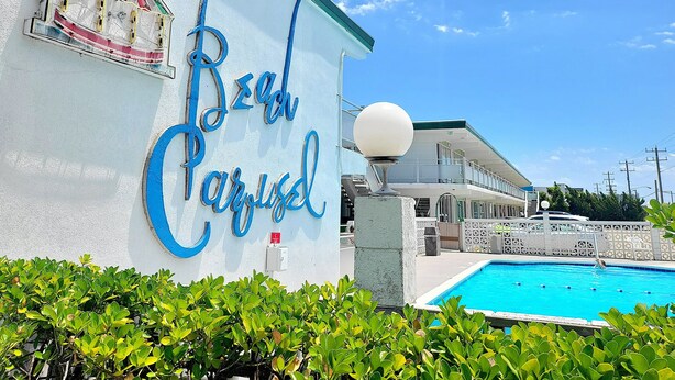 Un edificio con un letrero que dice "Beach Paradise" y una piscina.