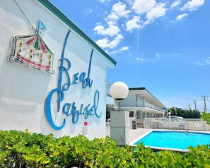 Un bâtiment sur lequel est apposée une enseigne indiquant « Paradis de plage », et une piscine.