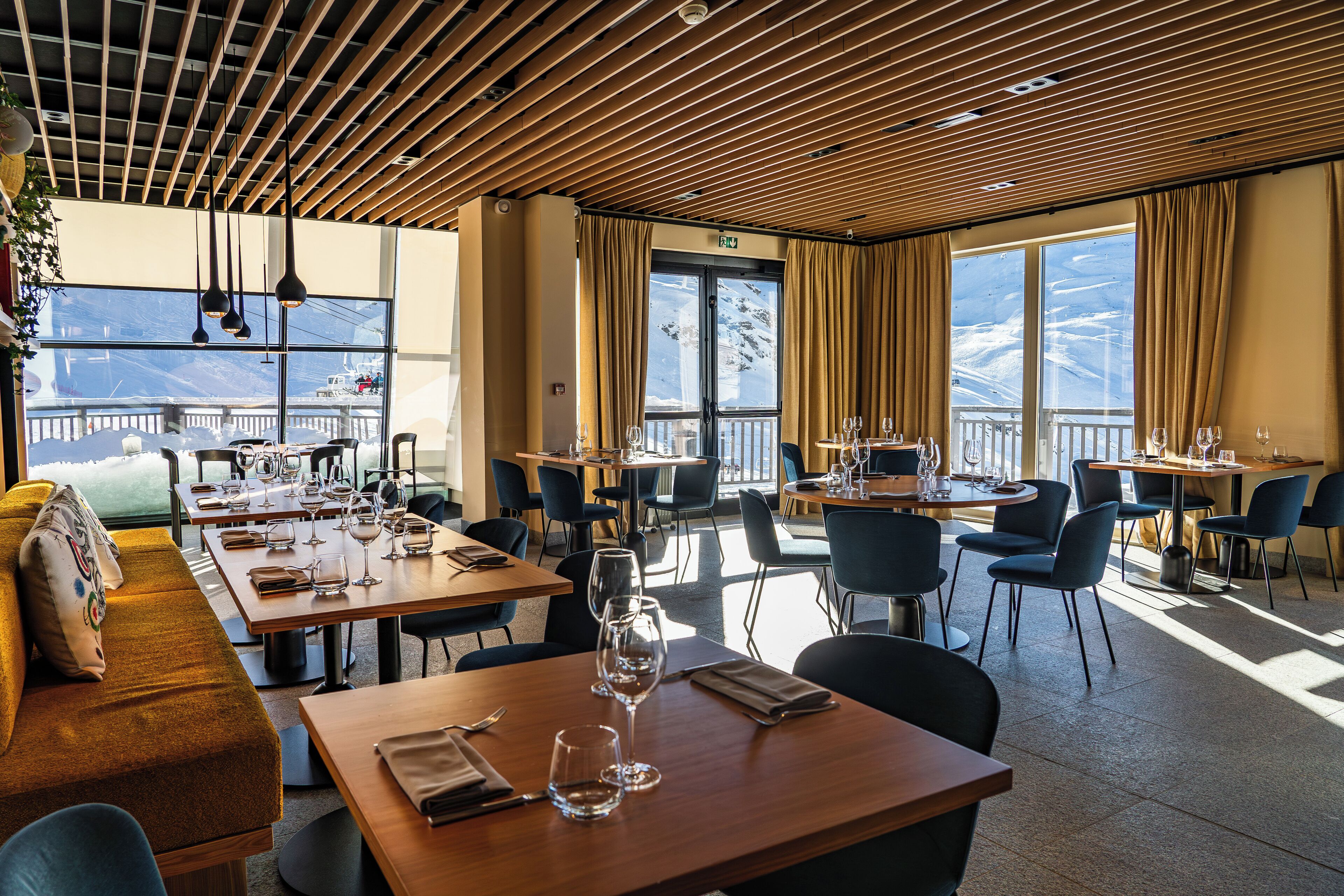 A restaurant with multiple tables, chairs, and a sofa.