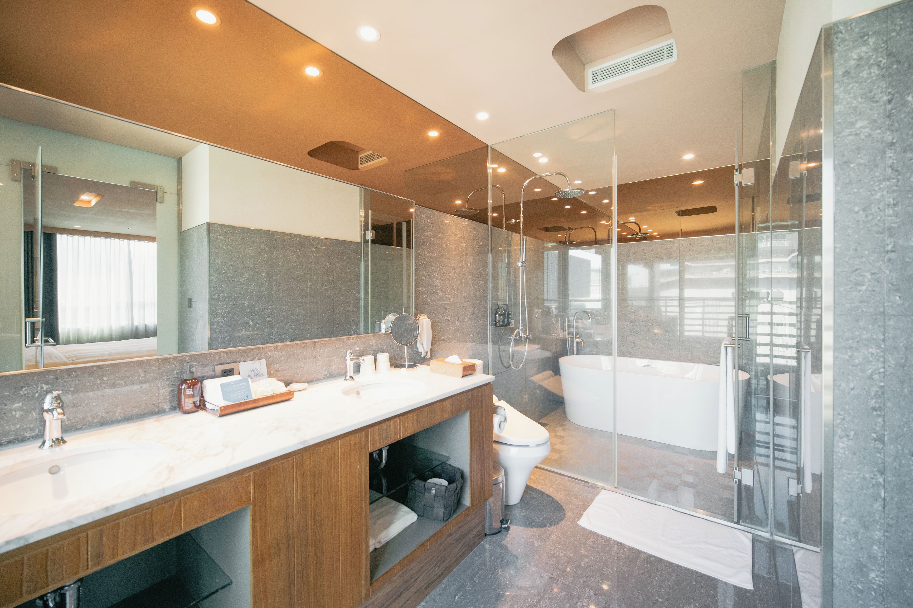 Une salle de bain moderne dotée d’une douche à parois de verre, d’une baignoire sur pieds et d’un meuble-lavabo avec un miroir.