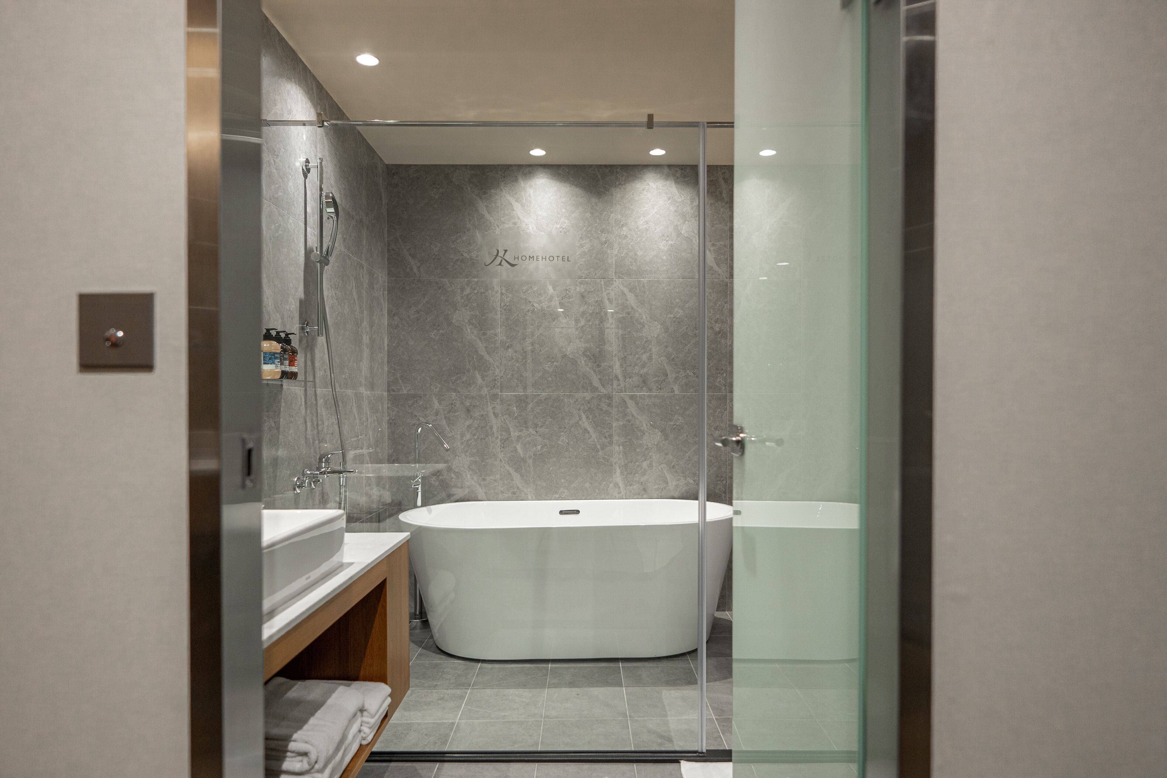 Une salle de bain moderne avec une baignoire sur pieds, une douche à parois de verre et un meuble-lavabo avec un miroir.