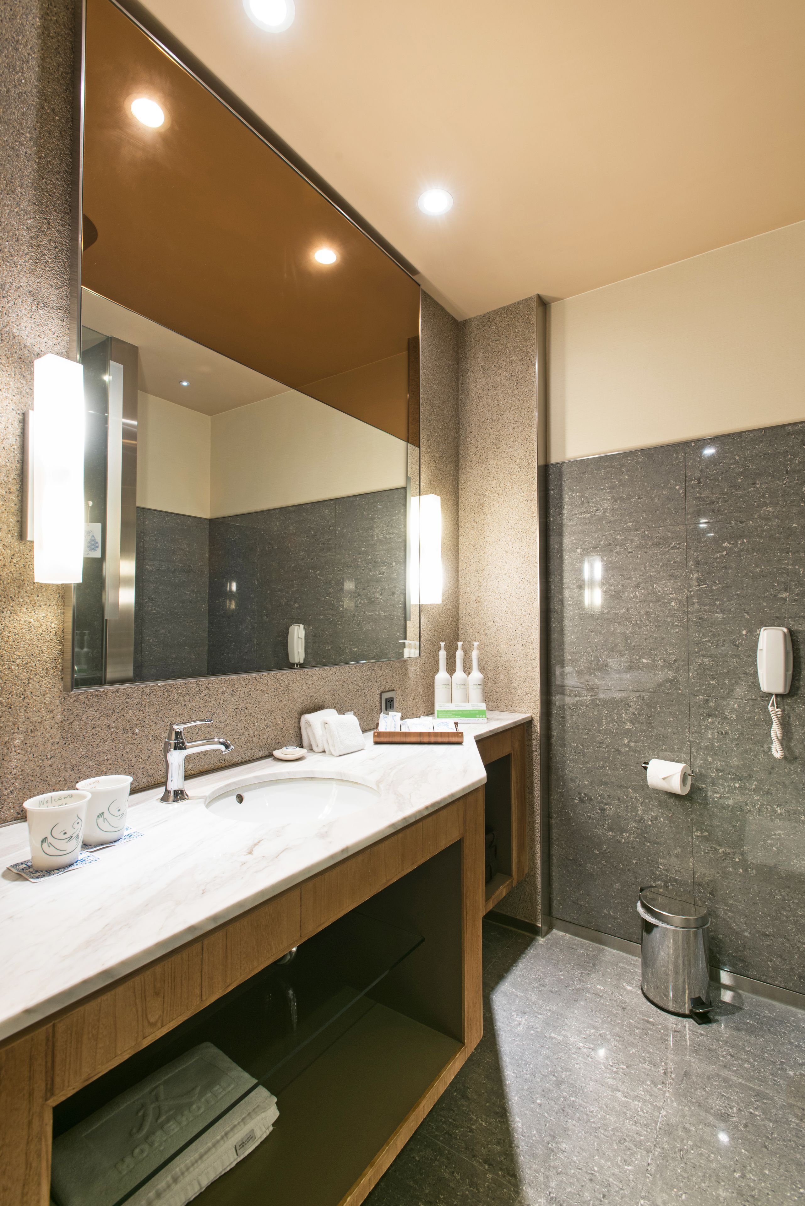Un baño moderno con un espejo grande, dos lavamanos, un mueble de tocador y una zona de ducha.