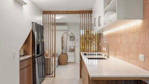 Une cuisine moderne avec des meubles en bois, un réfrigérateur en acier inoxydable et un grand îlot central doté d’un évier.