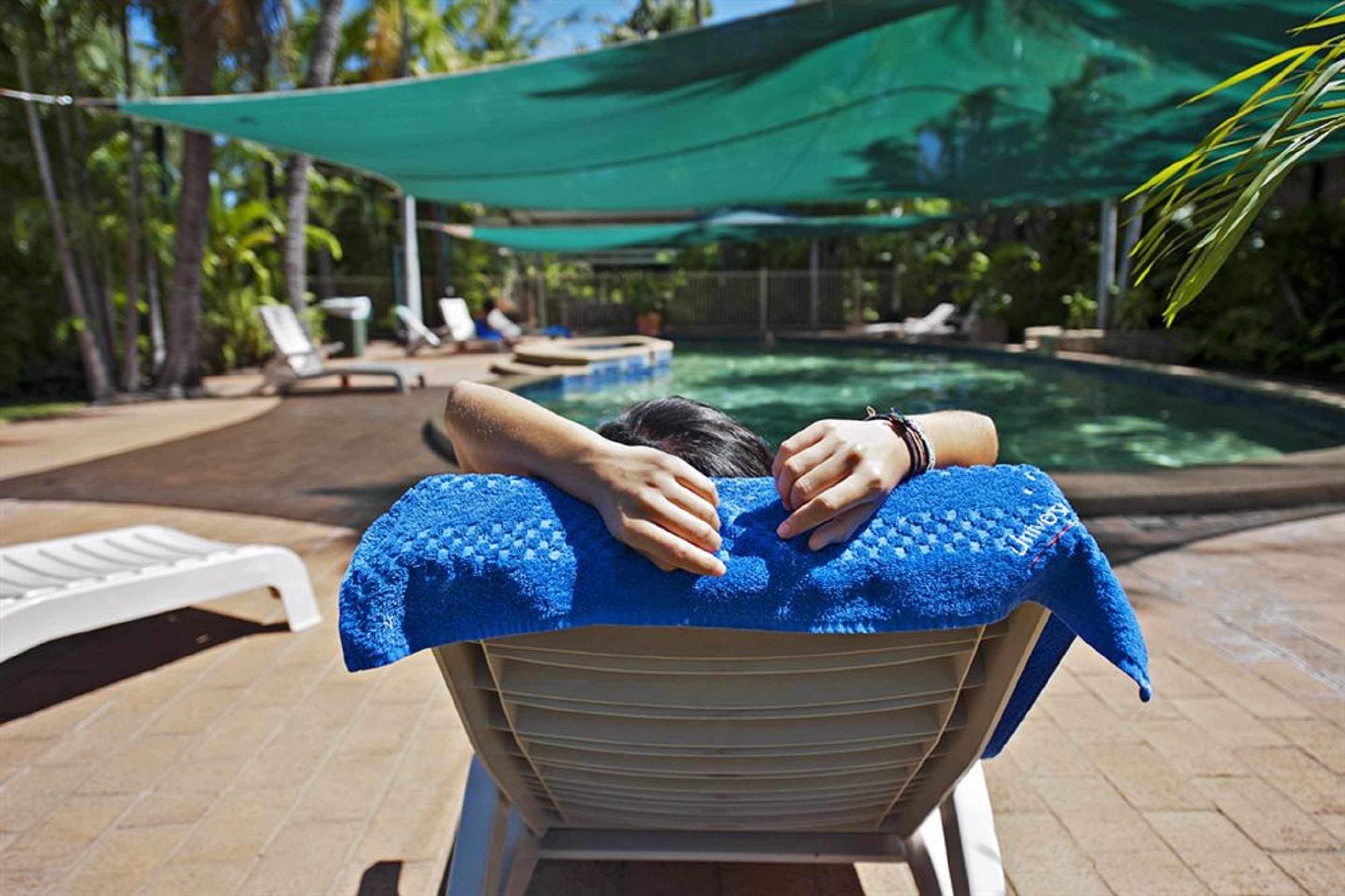 A poolside area with lounge chairs and a covered seating area.