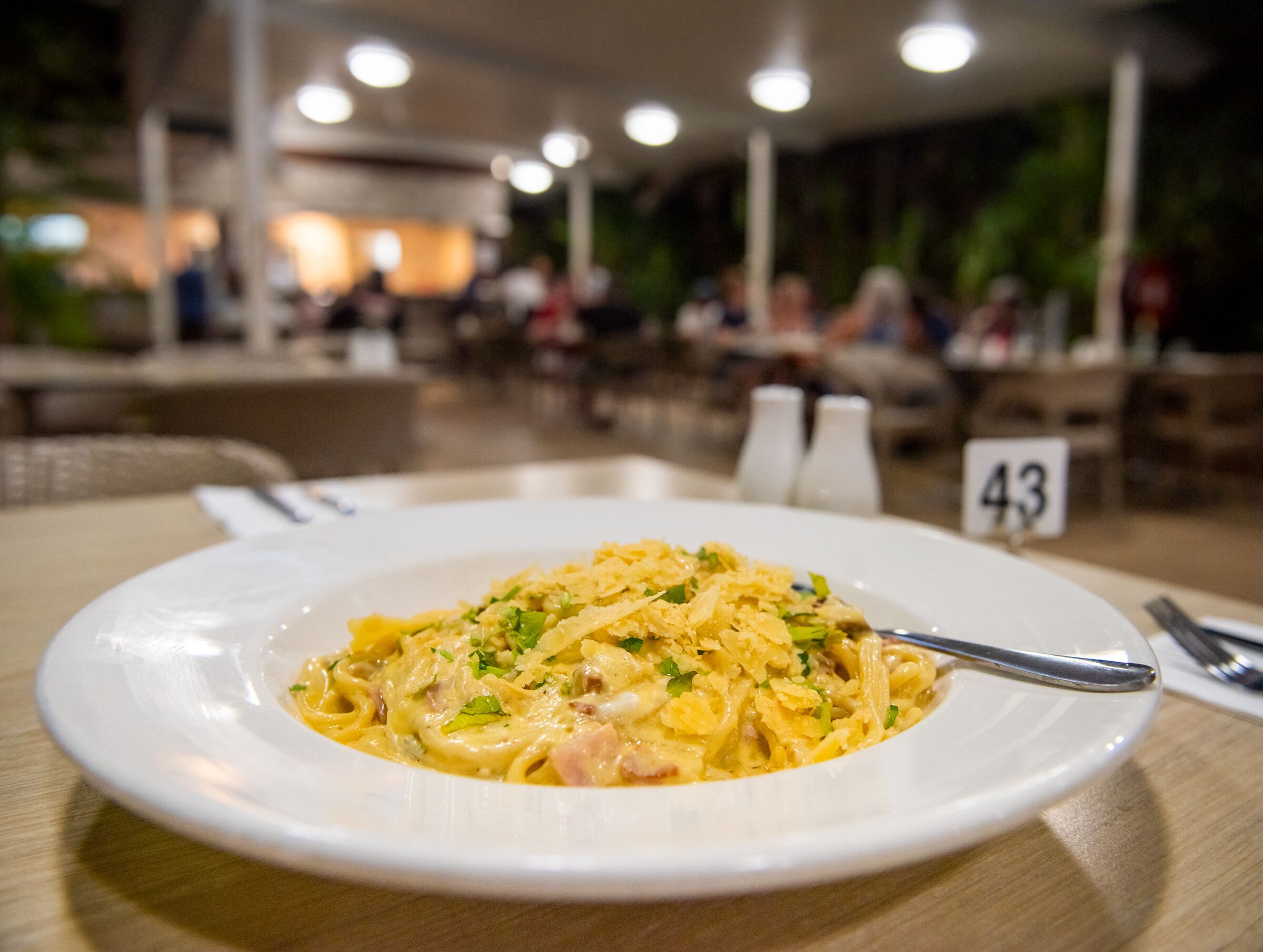 Ein Teller Pasta mit Gabel auf einem Tisch in einem Restaurant.