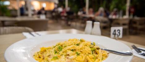 Ein Teller Pasta mit Gabel auf einem Tisch in einem Restaurant.