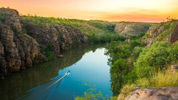 A river surrounded by rocky cliffs and dense greenery.