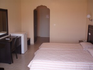 A bedroom with a bed, a desk, a chair, and a wardrobe.