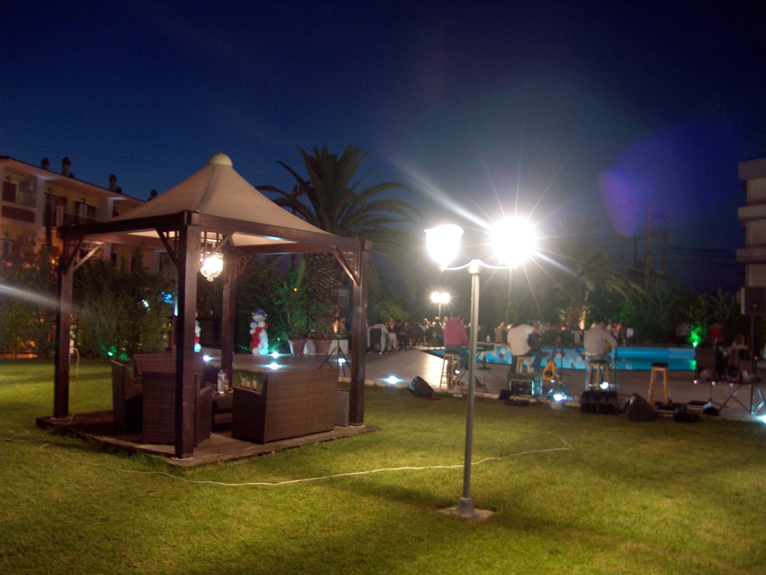 A gazebo with a table and chairs, surrounded by grass.