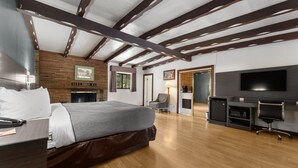 Une chambre d’hôtel moderne dotée d’un grand lit, d’un bureau, d’une télévision et d’une cheminée.