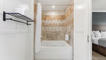 A bathroom with a bathtub, towel rack, and shower curtain.