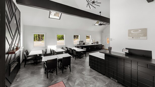 Un hall d’hôtel moderne avec un comptoir d’accueil, un espace salon et de grandes fenêtres.