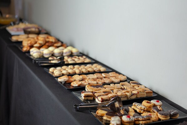 A buffet table with various pastries and desserts.