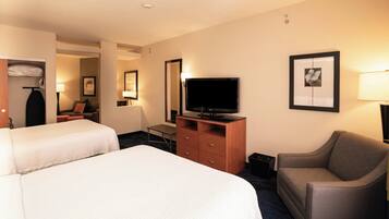 A hotel room with two beds, a TV, a desk, a chair, and a wardrobe.