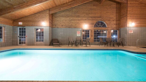 Una piscina interior con paredes de madera y suelo de baldosas.