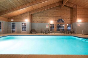 Una piscina interior con paredes de madera y suelo de baldosas.