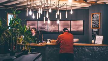 A bar area with hanging light bulbs, a counter, and a menu board.