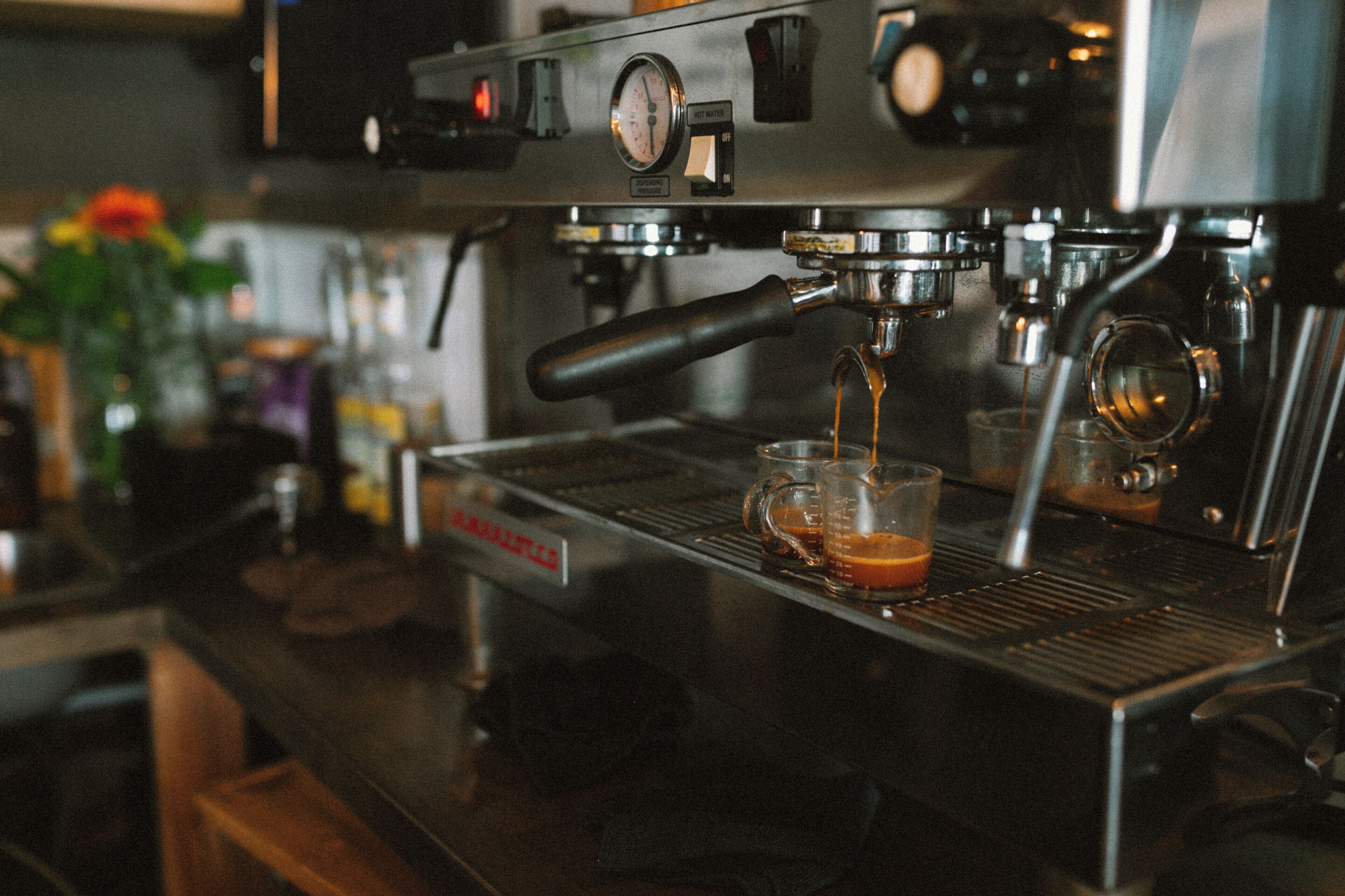 A coffee machine with a pressure gauge and a steam wand.