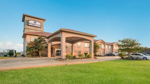 A Knights Inn with a central entrance, covered patio, and multiple buildings. - Knights Inn Bunkie (Bunkie)