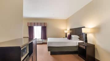 Una habitación de hotel con una cama, lámparas de noche, un televisor y una ventana con cortinas.