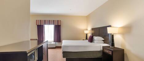 A hotel room with a bed, bedside lamps, a TV, and a window with curtains.