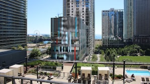 Un hotel moderno con piscina en la azotea, rodeado de rascacielos y vistas despejadas del horizonte urbano.