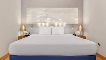 Una habitación de hotel con una cama grande, dos mesitas de noche, una lámpara de pared y una obra de arte abstracta moderna.